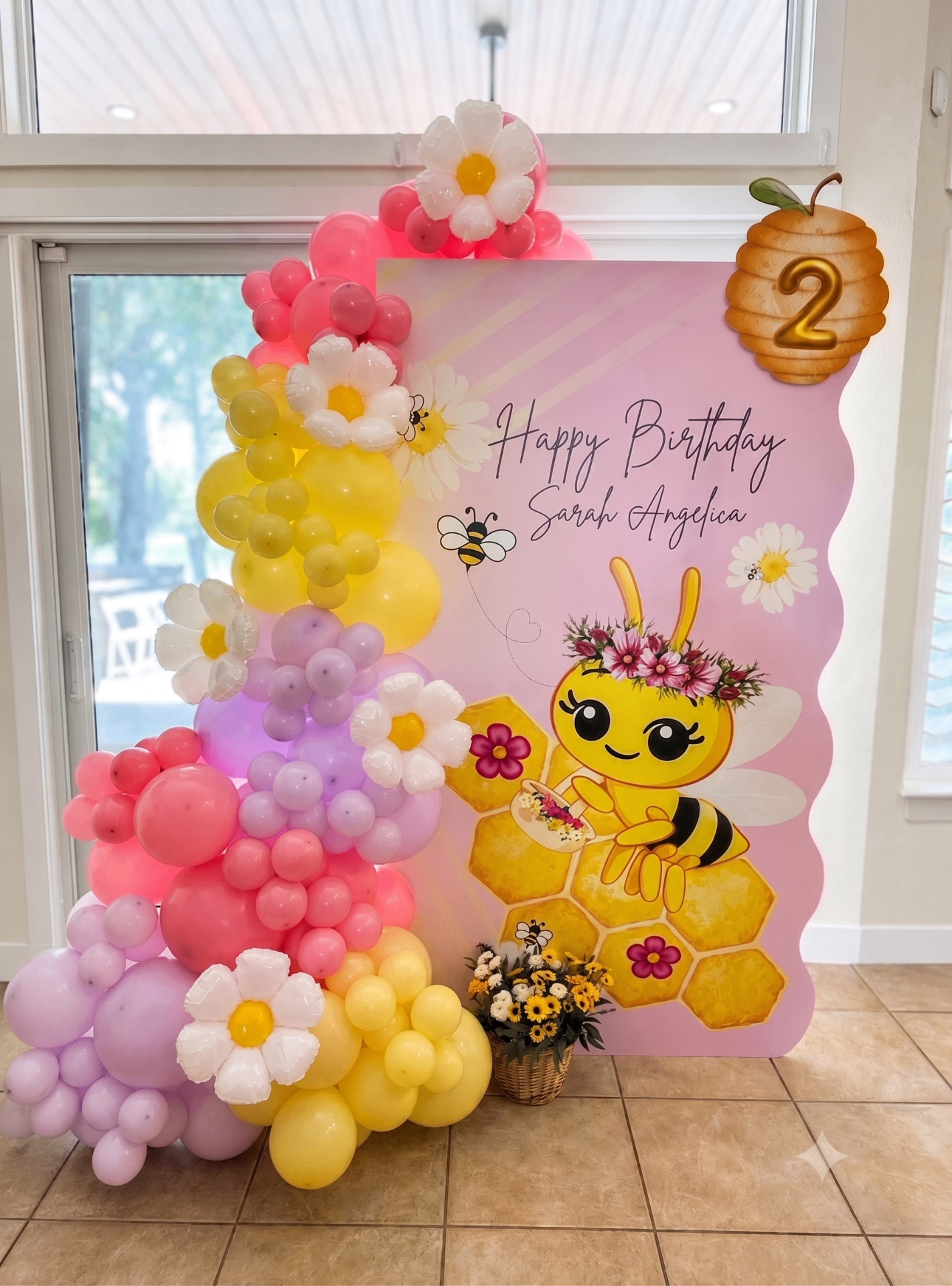 Pastel bee-themed birthday balloon backdrop